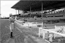  ?? MARK J. TERRILL/AP ?? Bugler Jay Cohen plays “First Call” as he calls the riders to post for the first race at Santa Anita Park to empty stands Saturday.