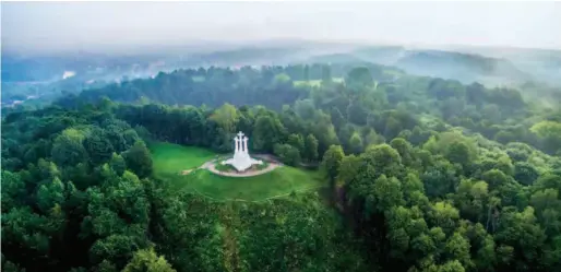  ??  ?? The Hill of Three Crosses, one of the tallest points in Vilnius. Legend goes that seven Franciscan friars were beheaded atop this hill. Wooden crosses were erected in the location as early as the 17th century. Opposite the hill is Castle Hill overlookin­g the city of Vilnius. by Laimonas Ciūnys