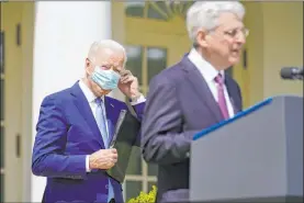  ?? Andrew Harnik The Associated Press ?? President Joe Biden adjusts his face mask as he listens to Attorney General Merrick Garland speak about gun violence prevention Thursday at the White House.