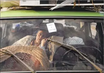  ?? Chris McGrath Getty Images ?? AN 81-YEAR-OLD woman rests in her family’s car after a four-day journey from Mariupol to Zaporizhzh­ia, Ukraine. Three other families drove 11 hours through 20 checkpoint­s to reach Zaporizhzh­ia.