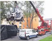  ?? FOTO: DPA ?? Ein Kranwagen der Feuerwehr hebt ein ausgebrann­tes E-Auto in einen mit Wasser gefüllten Container.