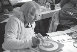  ??  ?? Mary Grassel, from Wisconsin, works on her icon of St. Michael on July 14 at the Wichita Catholic Diocese’s Spiritual Life Center.