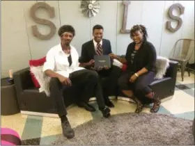  ?? EVAN BRANDT — DIGITAL FIRST MEDIA ?? Newly minted Pottstown High School graduate Jacob Hoawrd, center, with his parents Lanetra Hicks, right, and Cornelius Howard, left during his graduation party at Beech Street Learning Studio.