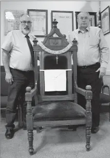  ?? Herald photo by Greg Bobinec ?? Past Grand Master Gerald Waldern and Past Master Wayne King from the Freemasons of Lethbridge stand with the vacant chair which symbolizes those who paid the supreme sacrifice and never returned, for the annual Vacant Chair Ceremony.