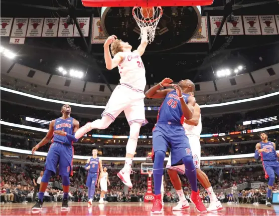  ?? JEFF HAYNES/ AP ?? Bulls forward Lauri Markkanen tips in a shot over Pistons forward Anthony Tolliver ( 43) in the first half of the Bulls’ season finale Wednesday at the United Center.