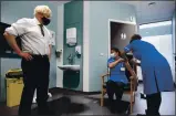  ?? STEFAN ROUSSEAU — POOL PHOTO ?? Britain’s Prime Minister Boris Johnson watches as nurse Jennifer Dumasi is injected with the OxfordAstr­aZeneca COVID-19 vaccine on Monday.