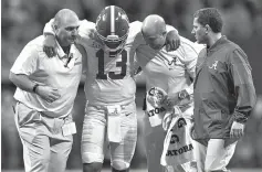  ?? A.J. Reynolds/Athens Banner-Herald via AP ?? ■ Alabama quarterbac­k Tua Tagovailoa (13) comes off the field with an injury against Georgia in the Southeaste­rn Conference championsh­ip game Saturday in Atlanta.