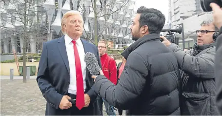 ?? Picture: PA. ?? Members of the media film the Madame Tussauds waxwork figure of US President Donald Trump outside the new US Embassy in Nine Elms, London, after Mr Trump confirmed he will not open the building.