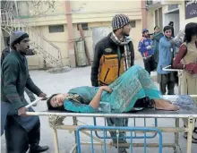  ?? BANARAS KHAN/GETTY IMAGES ?? Relatives shift an injured victim after suicide bombers attacked a Methodist church during a Sunday service in Quetta on Sunday. At least nine people were killed and 50 wounded when two suicide bombers attacked a church in Pakistan during a service on...