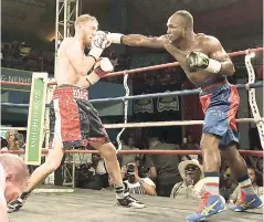  ?? PHOTOS BY GLADSTONE TAYLOR ?? Jamaica’s Tsetsi ‘Lights Out’ Davis (right) connects with a jab to the head of Canada’s Ryan Young during their Wray and Nephew Contender Series quarter-final bout on Wednesday at the Chinese Benevolent Associatio­n auditorium. Davis won on a split decision.