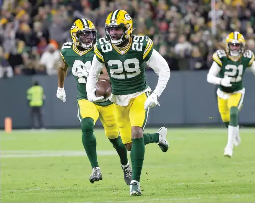  ?? GETTY IMAGES ?? Cornerback Rasul Douglas returns an intercepti­on for a touchdown during the third quarter of the Packers’ victory against the Rams at Lambeau Field.