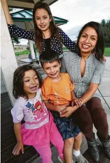  ?? David Zalubowski / Associated Press ?? Laura Peniche (der.) posa con sus tres hijos, Katalina, de 11 años, Athena, de 4 años, y Leonardo, de 6 años, en un patio de juegos del suburbio Thornton de Denver, Colorado.