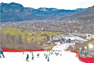  ?? AP PHOTO/ALESSANDRO TROVATI ?? On Jan. 4, athletes inspect a small strip of snow where they will compete in an alpine ski race, in Garmisch Partenkirc­hen, Germany. Global warming is having just as much say about when and where to hold ski races these days as the Internatio­nal Ski Federation.