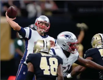  ?? AP PHOTO BILL FEIG ?? New England Patriots quarterbac­k Tom Brady (12) passes under pressure from New Orleans Saints strong safety Vonn Bell (48) and defensive end Alex Okafor (57) in the first half of an NFL football game in New Orleans, Sunday.