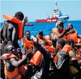  ?? ?? EU-Parlament in Brüssel (l.). Afrikanisc­he Migranten vor Lampedusa (r.)