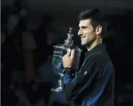  ?? ANDRES KUDACKI — THE ASSOCIATED PRESS ?? Novak Djokovic, of Serbia, holds the championsh­ip trophy after defeating Juan Martin del Potro, of Argentina, in the men’s final of the U.S. Open tennis tournament, Sunday in New York.