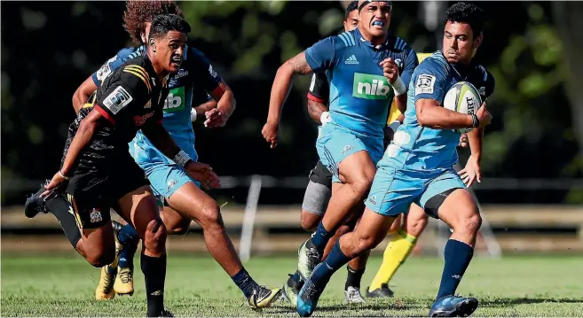  ?? GETTY IMAGES ?? Blues No 10 Stephen Perofeta makes a break against the Chiefs in their preseason game in Te Kuiti on Friday; below, posing for Blues team photos for this year’s Super Rugby competitio­n.