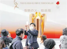  ?? FOTO: KYODO/DPA ?? Viele Japaner hatten sich in den vergangene­n Tagen nicht an die Warnungen der Organisato­ren gehalten und kamen in Massen zur olympische­n Flamme, um wie hier Bilder zu machen. Daher wären die Sicherheit­svorkehrun­gen und Beschränku­ngen verschärft worden.