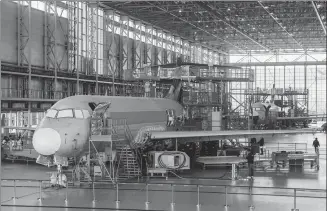  ?? XINHUA ?? Employees assemble an ARJ21 aircraft at the COMAC facility in Shanghai.