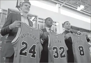  ?? G-Jun Yam / The Associated Press ?? Chicago Bulls seventh overall draft pick Lauri Markkanen (from left), Kris Dunn and Zach Levine show off their new jerseys.