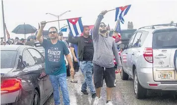  ?? PEDRO PORTAL/ASSOCIATED PRESS FILE ?? Cuban exiles block the Palmetto Expressway at Coral Way in support of protesters in Cuba on Tuesday in Miami. The demonstrat­ors were expressing solidarity with the thousands of Cubans who waged a rare weekend of protests around their island nation, shutting down a stretch of the major South Florida expressway for hours.