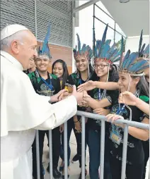  ?? OSSERVATOR­E ROMANO / REUTERS ?? Amazonía. El papa Francisco saluda con un grupo de jóvenes indígenas.