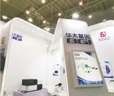  ?? IMAGINE CHINA / FILES ?? A company rep checks her smartphone at the stand of Chinese genome giant BGI Group during an expo in Wuhan
city in China in 2019. BGI's Canadian connection­s are causing concern among some security and ethics experts.