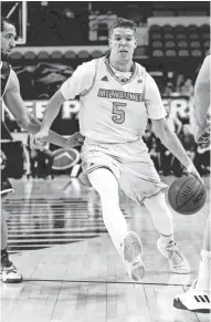  ?? RICK WOOD / MILWAUKEE JOURNAL SENTINEL ?? UWM's Cody Wichmann drives past UW-Green Bay's David Jespersen during Saturday’s game at the UWM Panther Arena.