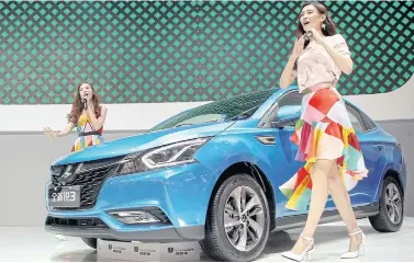  ??  ?? RIGHT Presenters show off a Taiwanese-made Luxgen S3 sedan during the Auto China 2016 show in Beijing in April last year.