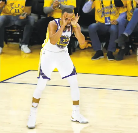  ?? Lachlan Cunningham / Getty Images ?? The Warriors’ Stephen Curry gestures to teammate Shaun Livingston after the latter made a shot in overtime against the Cavs.