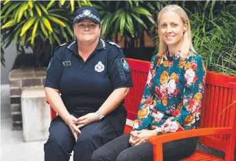  ?? ?? Sergeant Elise Feltham from the Townsville Police DFV and vulnerable persons unit sits on the new red bench with survivor Lorna Fox.