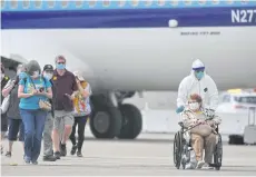  ?? AFP ?? Medical personnel help load passengers from the ‘Grand Princess’ cruise ship onto an aircraft at Oakland Internatio­nal Airport in Oakland, California on Tuesday.