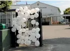  ??  ?? White balloons adorn the gates at Ha¯wera High School.