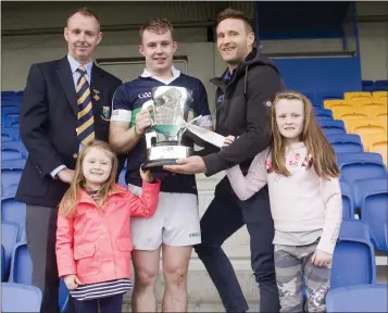  ??  ?? Paudi Reidy of Lightning Protection Ireland presents the cup to Bray Emmets captain Marc Lennon with Wicklow County Chairman Martin Fitzgerald and Paudi’s two daughters.