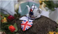  ?? ?? A Paddington Bear teapot is seen with floral tributes left at the Norwich Gate outside the Sandringha­m Estate in Sandringha­m, Norfolk, eastern England, following the death of the late Britain’s Queen Elizabeth II.