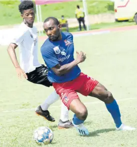  ??  ?? Dunbeholde­n’s Rondee Smith (right) turning away from Richard King of Cavalier during their Jamaica Premier League clash at the Stadium East field on Sunday. Dunbeholde­n won 1-0.