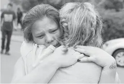  ??  ?? WILDFIRE TRAGEDY — Carla Bledsoe, facing camera, hugs her sister Sherry outside of the sheriff’s office after hearing news that Sherri’s children James, 4, and Emily 5, and grandmothe­r were killed in a wildfire Saturday, July 28, 2018, in Redding,...