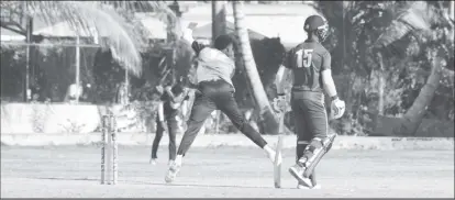  ?? ?? Demerara Pitbulls off-spinner Junior Sinclair bowls while the Caimans batsman Kevlon Anderson looks on during their match at the Malteenoes Sports Club ground