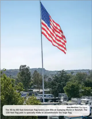  ?? Eddy Martinez/The Signal ?? The 40-by-80-foot American flag towers over RVs at Camping World in Newhall. The 130-foot flag pole is specially made to accommodat­e the huge flag.