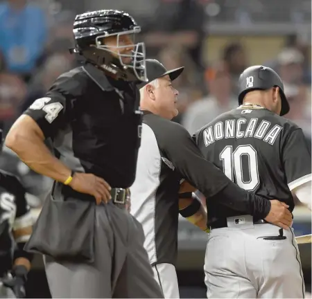  ?? HANNAH FOSLIEN/GETTY IMAGES ?? Rick Renteria leads Yoan Moncada away from an argument with umpire CB Bucknor after a strikeout.