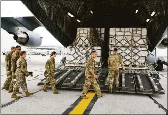  ?? Michael Conroy / Associated Press ?? Crew members of a C-17 begin to unload a plane full of baby formula at the Indianapol­is Internatio­nal Airport on Sunday. The 132 pallets of Nestlé Health Science Alfamino Infant and Alfamino Junior formula arrived from Ramstein Air Base in Germany.