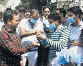  ??  ?? Volunteers distribute masks to residents in Surat on Wednesday.
ANI