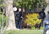  ?? ?? An officer with the Chico Police Department stands with gun drawn outside an apartment on White Avenue in Chico on Sunday.