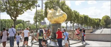  ?? — AFP photo ?? People walk around the ‘Flamme de la Liberté’ (Liberty Flame), an original monument Princess Diana fans turned into a commemorat­ion stele, in Paris last Monday.