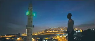  ??  ?? A MUSLIM MAN prays near an east Jerusalem mosque last November.