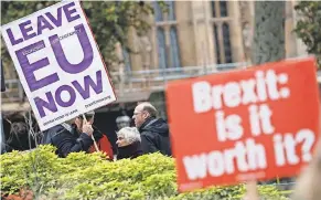  ?? ALASTAIR GRANT/AP ?? Pro- and anti-Brexit protesters vie for media attention near Parliament in London. Britain’s Prime Minister Theresa May still faces the threat of a no-confidence vote from Conservati­ve Party lawmakers.