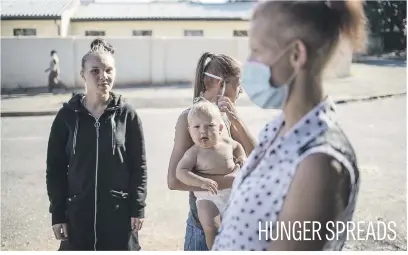  ?? Picture: AFP ?? Vrededorp residents stand outside their house to wait for a food drop-off organised by a charity in Johannesbu­rg this week.