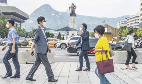  ??  ?? People wearing face masks are seen walking on a street in Seoul, South Korea, Sept. 15, 2020. (Photo by Getty Images)