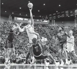  ?? K.C. ALFRED U-T ?? Aztecs' Micah Parrish is fouled by Troy's Christyon Eugene (5) on a shot Monday.