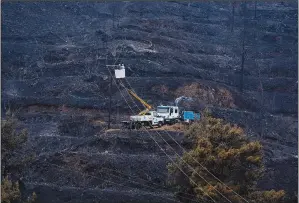  ??  ?? Electricit­y power engineers at work
Sunday in the burned Larnaca mountain region.